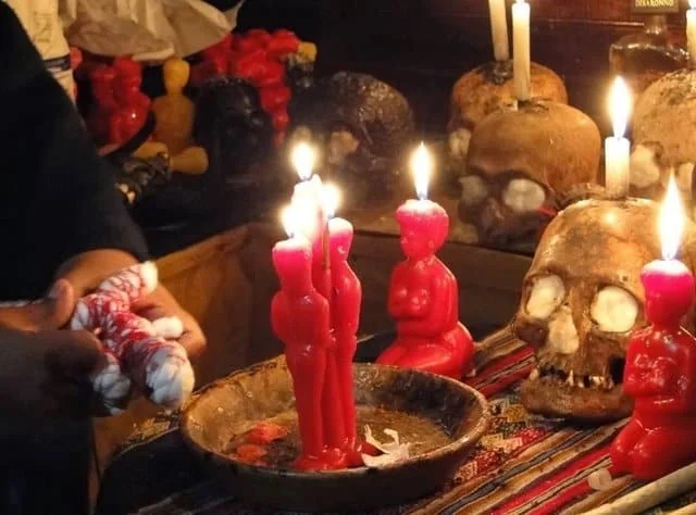 Ritual de amarre de amor con velas rojas de pareja, un muñeco atado con cordón y velas encendidas